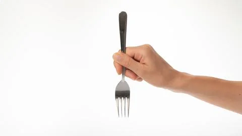 Fork in a woman's hand on a white background gesture to prick on a fork Stock Photos
