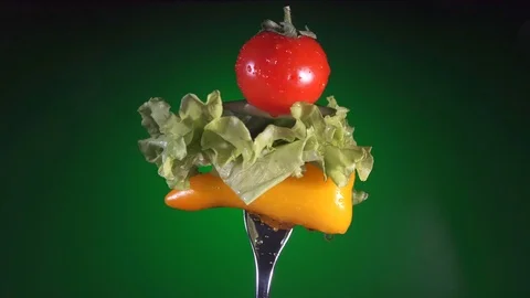 Fork with yellow pepper slices of cucumber, radish and lettuce rotates green Stock-Footage 86611345