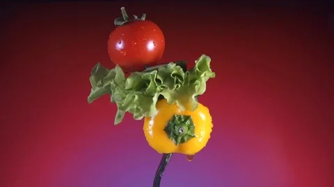 Fork with yellow pepper slices of cucumber, radish and lettuce rotates red Stock-Footage 86611573