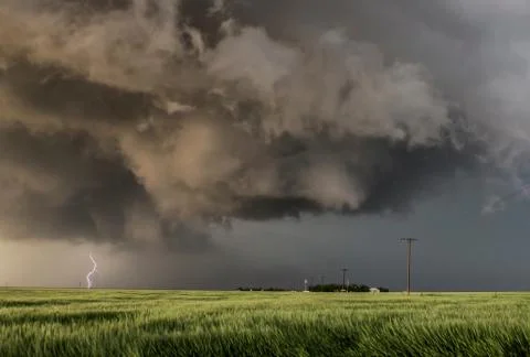 Forking lightning bolt from tornadic storm, turbulent updraft in the foreground Stock Photos