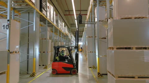 Forklift driver navigates narrow warehouse aisle. Stock Footage 307953770