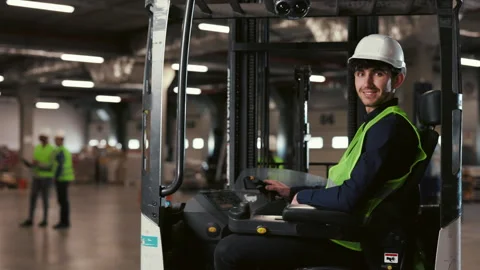 Forklift Driver in Protective Attire Positively Posed in Fork Truck in Logistics Stock-Footage 258323261