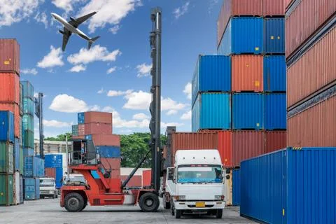 Forklift handling container box loading at docks with truck and airplane flyi Stock Photos