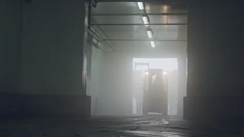 Forklift lifting pallets in a dark cooled warehouse Vidéo 104903540