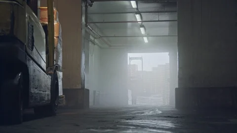 Forklift lifting pallets in a dark cooled warehouse Vidéo 104903781