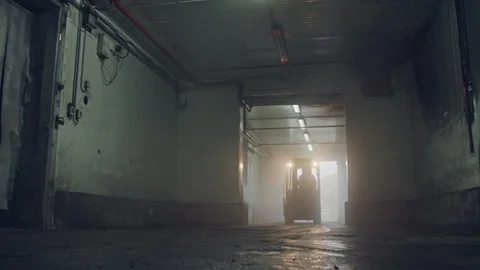 Forklift lifting pallets in a dark cooled warehouse Vidéo 104903956