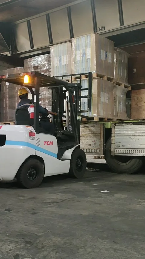 Forklift Loading Cargo onto Truck in Warehouse Stock Footage 303370125