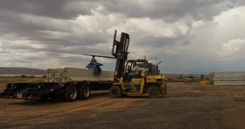Forklift loading concrete road barriers onto a flatbed trailer in Arizona. Stock Footage 235104319