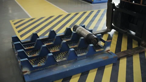 Forklift loading oil drilling tool onto metal storage rack Stock Footage 309324363