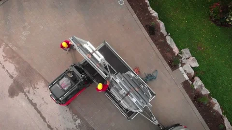 Forklift loading window frames in machine trailer. Building under construction Stock Footage 206029574