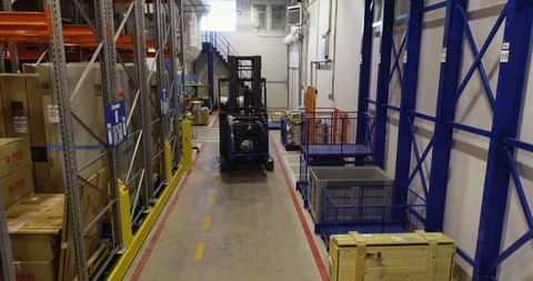 Forklift moves between rows with goods lying in a warehouse Stock Footage 126953168