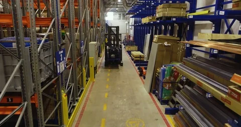 Forklift moves between rows with goods lying in a warehouse Stock Footage 126953427