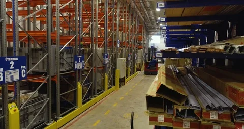 Forklift moves between rows with goods lying in a warehouse Stock Footage 126953449
