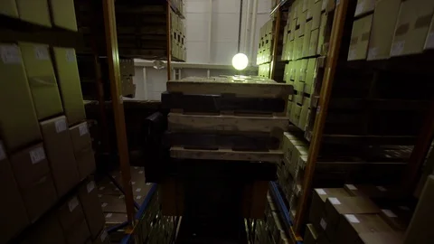 Forklift moving pallets with cardboard boxes in a warehouse with high-bay racks Stock-Footage 129477532