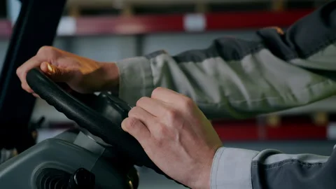 Forklift Operator Hands on Steering Wheel in Industrial Warehouse Видео 345012518