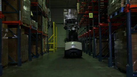 Forklift operator. Storing palette of boxes on top shelf in warehouse Stock Footage 102185683