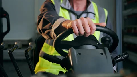 Forklift Operator Using Steering Wheel and Control Lever in Warehouse. Vídeo Stock 345013319
