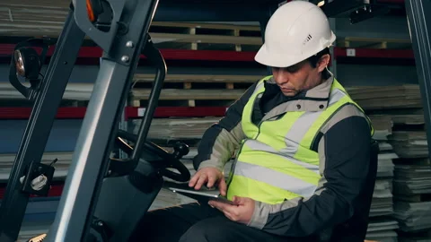 Forklift Operator Using Tablet While Working in Warehouse Vídeos de archivo 345013224