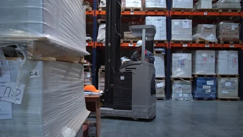 Forklift rides out of pallets with boxes. Behind the wheel of a worker in Stock-Footage 111768049