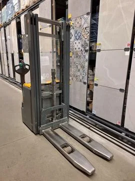 Forklift stands between rows of goods in a construction hypermarket Stockfoto's