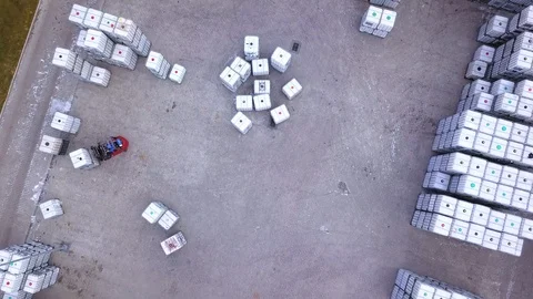 Forklift trucks move between large shelves at outside warehouse and load pall Stock Footage 88128232