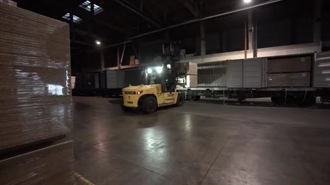 Forklifts load pallets with OSB boards into a freight train car. Video stock 172418307