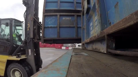 Forkllift unloading offshore waste skip from flatbed trailer Stock Footage 84263454