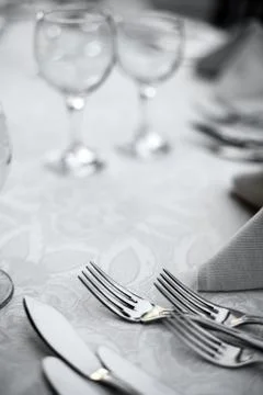 Forks and knives on a table Stock Photos