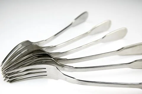 Forks arranged in series on the kitchen table Stock Photos