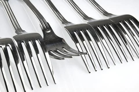 Forks arranged in series on the kitchen table Stock Photos