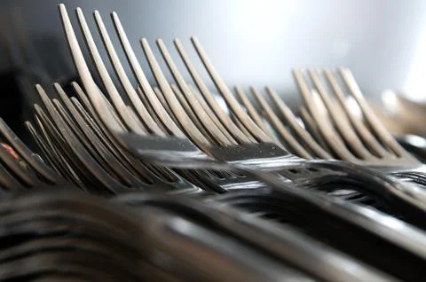 Forks arranged in series on the kitchen table Stock Photos