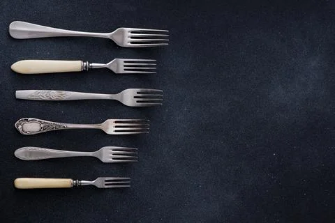 Forks on a black background. Set of old different cutlery for food. Stock Photos