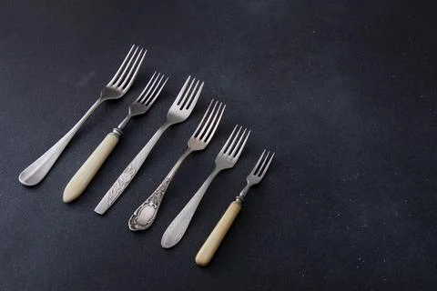 Forks on a black background. Set of old different cutlery for food. Stock Photos
