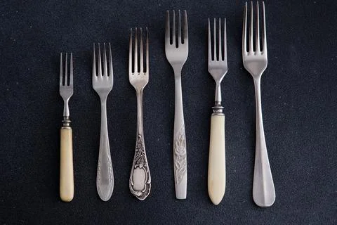 Forks on a black background. Set of old different cutlery for food. Stock Photos