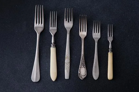 Forks on a black background. Set of old different cutlery for food. Stock Photos
