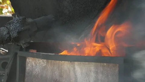 Forks of fire playing in a metallic brazier placed outdoors on a sunny day Stock Footage 102275067
