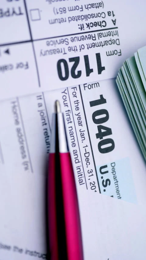 Form 1040 tax document and red pen for annual filing and record keeping Stock Footage 345026140