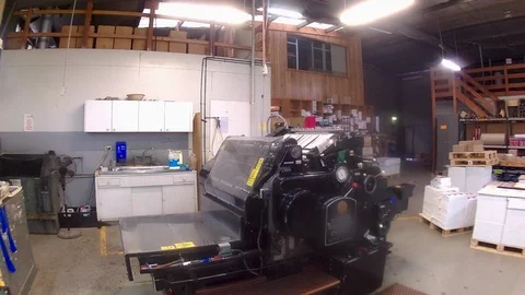 Form cutting printing press in operation at a large offset printing factory Stock Footage 100632124