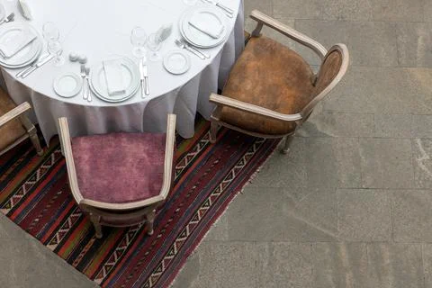 A formal dining setup featuring a round table with a white tablecloth Foto stock