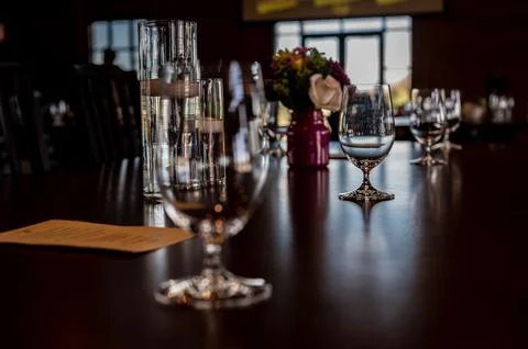 Formal dinner setting placement with an empty glass and light reflecting off the Stock Photos