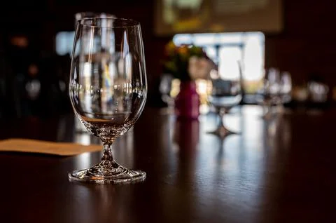 Formal dinner setting placement with an empty glass and light reflecting off the Stock Photos