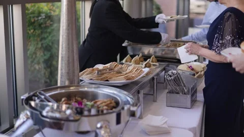 A formal event featuring a buffet with diverse food items, including flatbreads Stock Footage 296686643