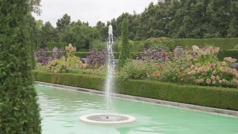 A formal garden with a long turquoise pool and a central fountain Stockbeeldmateriaal 332580181