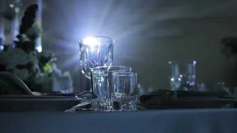 Formal table setting with empty crystal glasses, cutlery, and napkins Video stock 347580833