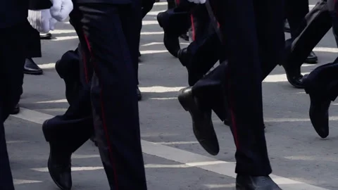 Formal uniformed group marching in coordinated formation on a city street Stock Footage 312674985