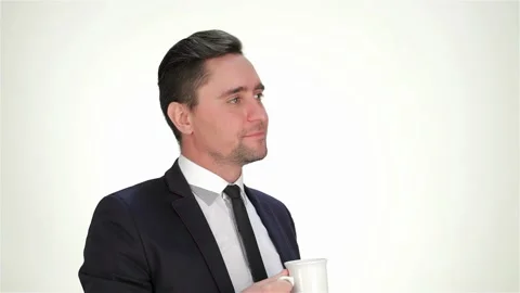 Formally dressed businessman drink from a cup, smiling and showing thumb Stock Footage 252652053