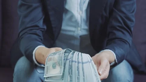 Formally dressed man and waving a wad of dollars, close-up. Stock Footage 242097944