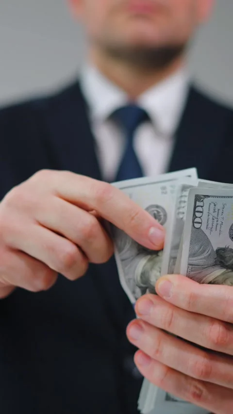 Formally dressed man carelessly throws US Dollar bills towards the camera Stockbeeldmateriaal 342756827