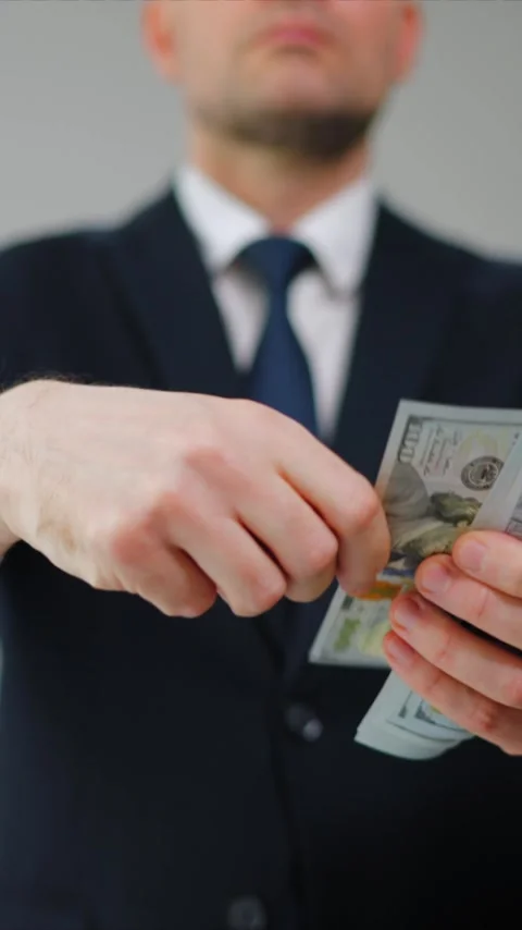 Formally dressed man carelessly throws US Dollar bills towards the camera Video stock 342834191