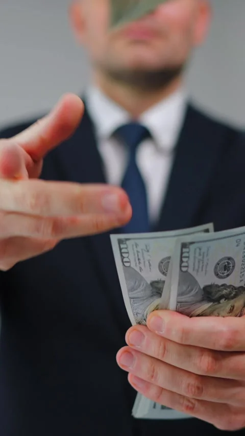 Formally dressed man carelessly throws US Dollar bills towards the camera Stock Footage 342835405